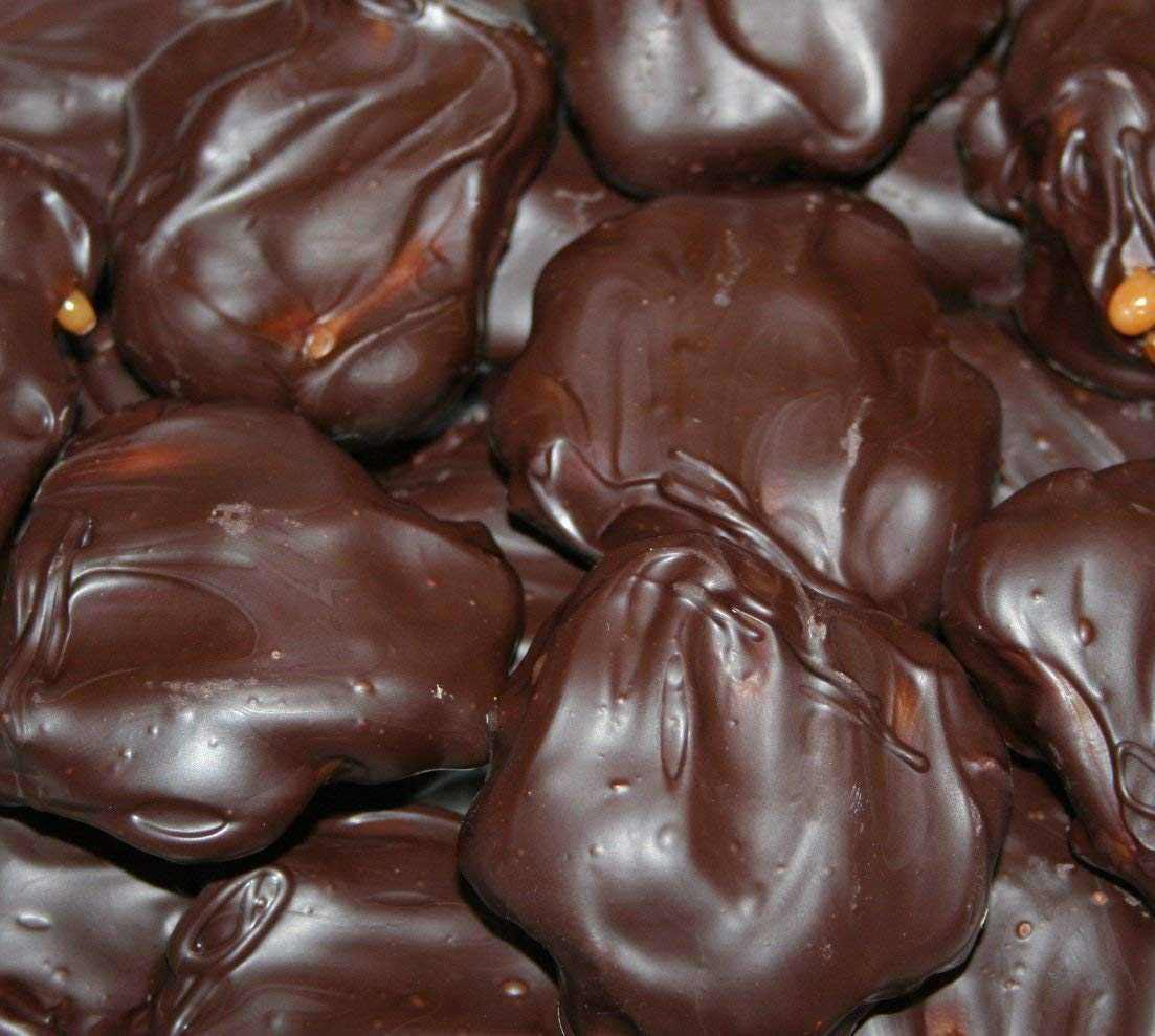 Close-up of Caramel Pecan Clusters Covered in Chocolate with glossy dark chocolate coating and crunchy pecans